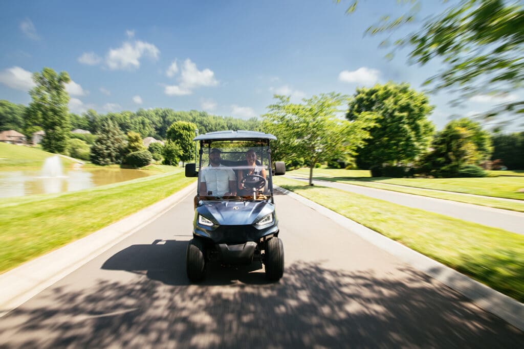 Driving a golf cart through a neighborhood - golf carts for sale near you